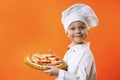 Funny boy chef cooked pizza on a board