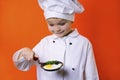 Funny boy chef keeps a fried egg in a frying pan Royalty Free Stock Photo