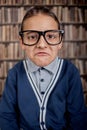 funny boy with eye glasses in library grumpy young boy in library Royalty Free Stock Photo
