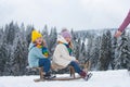 Funny boy and girl having fun with a sleigh in winter. Cute children playing in a snow. Winter activities for kids Royalty Free Stock Photo