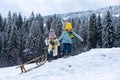 Funny boy and girl having fun with a sleigh in winter. Cute children playing in a snow. Winter activities for kids Royalty Free Stock Photo