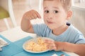 Funny boy has Breakfast eggs alone holding a spoon Royalty Free Stock Photo