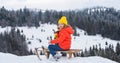 Funny boy having fun with a sleigh in winter. Cute children playing in a snow on snowy nature landscape. Winter Royalty Free Stock Photo