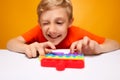 Boy makes funny faces in front of a fashionable silicone anti-stress toy trying to push the balls and pop them Royalty Free Stock Photo