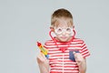 Funny boy playing doctor. Toy syringe, glasses and phonendoscope. Portrait Royalty Free Stock Photo