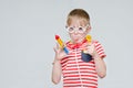 Funny boy playing doctor. Toy syringe, glasses and phonendoscope. Portrait Royalty Free Stock Photo