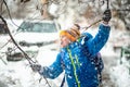 Funny boy pouring snow on himself from tree branches during snowfall in winter while walking outdoors Royalty Free Stock Photo