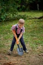 Funny boy with shovel in garden Royalty Free Stock Photo