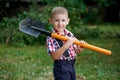 Funny boy with shovel in garden Royalty Free Stock Photo