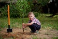 Funny boy with shovel in garden Royalty Free Stock Photo