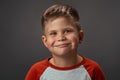 Funny boy smiles at the camera in the studio. Portrait of a smiling child. High quality photo