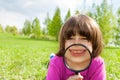 Funny boy smiles through magnifier, lays on grass Royalty Free Stock Photo