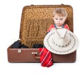 A funny boy with sombrero is in the suitcase