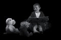 Funny boy with a teddy bear reading a book for bed time in artistic conversion Royalty Free Stock Photo