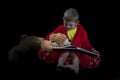 Funny boy with teddy bear reading a book before bed time Royalty Free Stock Photo