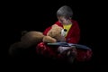 Funny boy with teddy bear reading a book before bed time Royalty Free Stock Photo