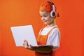 Funny boy in uniform builder and headphones looking laptop Royalty Free Stock Photo