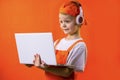 Funny boy in uniform builder and headphones looking laptop Royalty Free Stock Photo