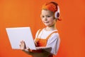 Funny boy in uniform builder and headphones looking laptop Royalty Free Stock Photo
