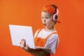 Funny boy in uniform builder and headphones looking laptop Royalty Free Stock Photo