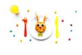 Funny breakfast for children. Meal with cheesecake in shape of hare. White background top view Royalty Free Stock Photo