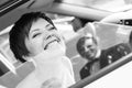 Funny bride in the car smiling groom. Woman 35 years. Wedding