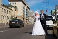 Funny bride and groom catch taxi on the street Royalty Free Stock Photo