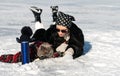 Funny British fluffy cat and a girlare fishing with winter fishing rods on the ice of the lake.