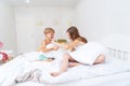 Funny brother and sister fighting pillow on bed morning bedroom kids boy and girl playing together Royalty Free Stock Photo