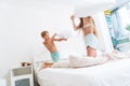 Funny brother and sister fighting pillow on bed morning bedroom kids boy and girl playing together Royalty Free Stock Photo