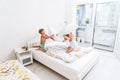 Funny brother and sister fighting pillow on bed morning bedroom kids boy and girl playing together Royalty Free Stock Photo