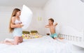 Funny brother and sister fighting pillow on bed morning bedroom kids boy and girl playing together Royalty Free Stock Photo