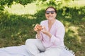 Funny brunette girl in sunglasses eating pizza on nature background. Attractive girl feels hungry and loves the taste