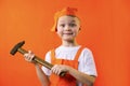 Funny builder boy in uniform holds a hammer Royalty Free Stock Photo