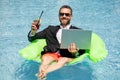 Funny business man in a business suit floating in the water in the pool. Remote work. Crazy freelancer. Business and Royalty Free Stock Photo