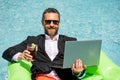 Funny business man in a business suit floating in the water in the pool. Remote summer work online. Crazy freelancer Royalty Free Stock Photo