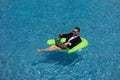 Funny business man in a business suit floating in the water in the pool. Remote summer work online. Crazy freelancer Royalty Free Stock Photo