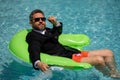 Funny business man in a business suit works for a laptop standing in the water in pool. Remote work. Crazy freelancer Royalty Free Stock Photo