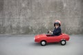 Funny businessman driving retro pedal car outdoor Royalty Free Stock Photo