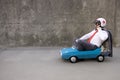 Funny businessman driving retro pedal car outdoor Royalty Free Stock Photo