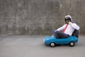 Funny businessman driving retro pedal car outdoor Royalty Free Stock Photo