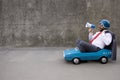 Funny businessman driving retro pedal car outdoor Royalty Free Stock Photo