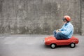 Funny businessman driving retro pedal car outdoor Royalty Free Stock Photo