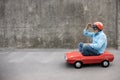 Funny businessman driving retro pedal car outdoor Royalty Free Stock Photo