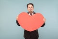 Funny businessman holding big red heart and send kiss Royalty Free Stock Photo