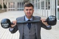 Funny businessman lifting heavy weights