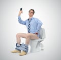 Funny businessman photographing himself in the toilet.