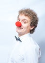 Funny businessman with red clown nose studio shot. Royalty Free Stock Photo