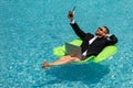 Funny businessman in suit working with computer on the sea beach. Summer holiday, outdoor and business travel concept Royalty Free Stock Photo