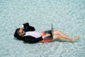 Funny businessman in suit working with computer on the sea beach. Summer holiday, outdoor and business travel concept Royalty Free Stock Photo